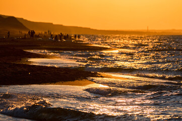 Beautiful sunset seashore landscape with people and mountains on background