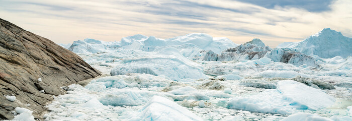 Wall Mural - Global warming - Greenland Iceberg landscape of Ilulissat icefjord with giant icebergs. Icebergs from melting glacier. Arctic nature heavily affected by climate change.