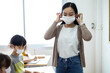 © JR-50 - An Asian female teacher was wearing a face mask while teaching students in the classroom. Group of Diversity students wear a protective face mask to prevent the spread of the Coronavirus.