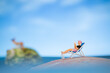 Miniature people sunbathing on a seashell with blue sky background , summer vacation concept