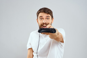 Wall Mural - A man with a joystick in his hands fun games lifestyle white t-shirt light background