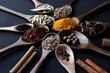 Colourful various herbs and spices for cooking on dark background.