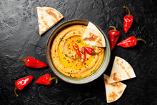 Roasted Red Pepper Hummus With Pita Bread On Black Background. Top View