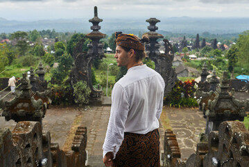 A young European guy in traditional Balinese clothes.