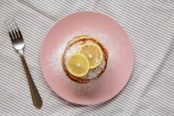 Wall Mural - Homemade Lemon Ricotta Pancakes on a pink plate, top view. Flat lay, overhead, from above.