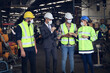 © torsakh - Leader or manager using tablet and meeting with engineer and technician while line walk in factory workplace, team wear face mask whine working at maintenance machine shop