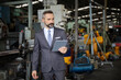 © torsakh - A smart professional business manager wear suit is working or inspect and radio to ordering in factory or production line, smart leader or entrepreneurship concept