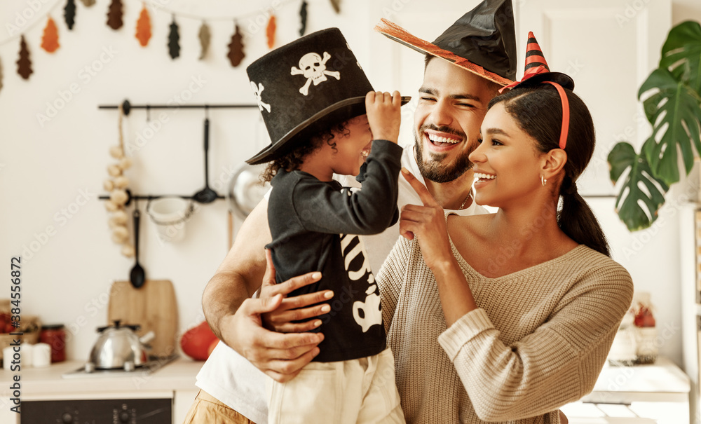 happy multiethnic family mom, dad and son have fun and celebrate Halloween at home. - obrazy, fototapety, plakaty 