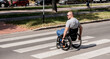 © romaset - Handicapped man in wheelchair crossing street road