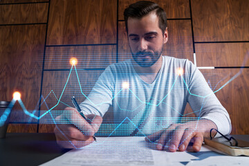 Good looking man working on fin project. Multiexposure. Financial graph Hologram.