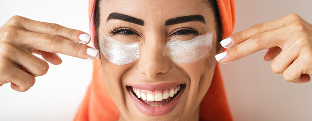 Happy girl applying daily facial cream - Young woman having skin care spa day - Healthy beauty clean treatment and cosmetology products concept