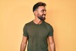 © Krakenimages.com - Young hispanic man wearing casual clothes looking away to side with smile on face, natural expression. laughing confident.