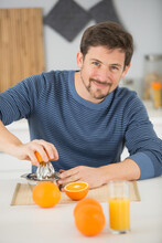 Man Squeezes Oranges For An Orange Juice