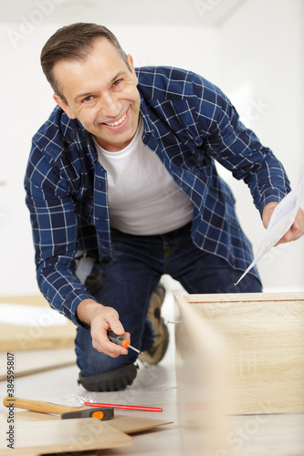 happy contractor repairing furniture at home