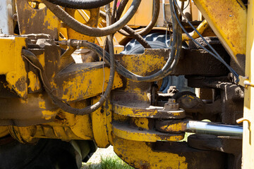 Closeup of a yellow tractor with heavy wheels in a field