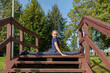 © Андрей Рыков - Ten year old caucasian girl doing front splits between handrail of wooden stairs in city park on sunny summer morning. Outdoor sport theme.