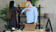 © viacheslav - Man and woman wear protective medical masks on faces greet elbows employees work together with laptop computer in office