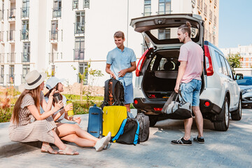 Wall Mural - friends load car trunk with baggage