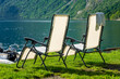 Urlaub in Süd-Norwegen: der epische Geiranger Fjord - zwei Liegestühle am idyllischen Campingplatz