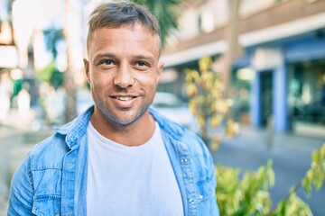 Young caucasian man smiling happy walking at the city.