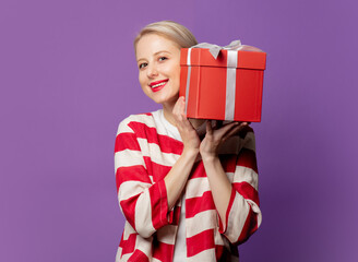 Sticker - Beautiful blonde in red jacket with gift box on purple background