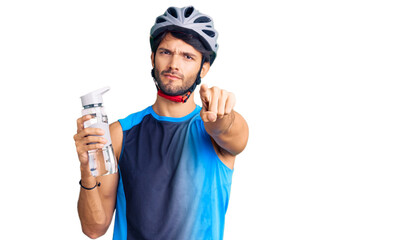 Poster - Handsome hispanic man wearing bike helmet and holding water bottle pointing with finger to the camera and to you, confident gesture looking serious