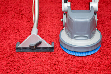 Professionally vacuum cleaner spray nozzle and disc machine on red shaggy carpet. General or regular cleanup. Commercial cleaning company concept. Closeup. Front view.