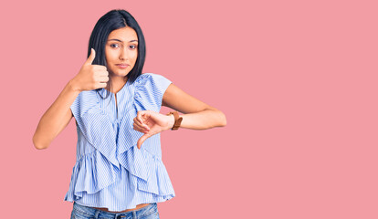 Canvas Print - Young beautiful latin girl wearing casual clothes doing thumbs up and down, disagreement and agreement expression. crazy conflict