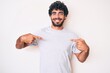 © Krakenimages.com - Handsome young man with curly hair and bear wearing casual tshirt looking confident with smile on face, pointing oneself with fingers proud and happy.