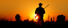 A Silhouette Of A Male Hunter Carrying A Shotgun. He Could Be Hunting Pheasant, Chukar, Partridge, Grouse, Dove Or Quail.