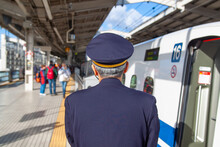 Shinkansen Nozomi Bullet Train Conductor Checks The Platform As The Train Is Getting Ready To Leave, Back Portrait, No Face, Elderly Man In A Uniform