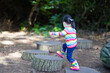 © M-image - young girl jumping between the timber in the forest park