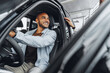 © fotofabrika - Young attractive woman salesperson in car showroom showing a car to her male client
