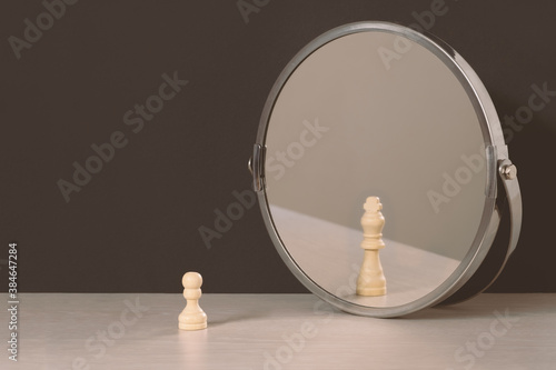 Pawn sees himself as a king looking in the mirror. Self-regard or vanity concept.