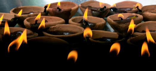 Traditional clay diya lamps lit during diwali celebration, A group of decorative Indian lamps