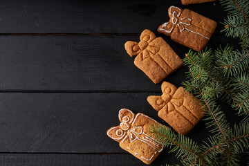 Wall Mural - Tasty homemade cookies with icing on dark table with fir branch. Christmas and winter concept