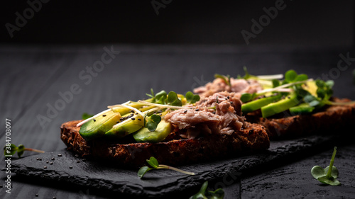 Toast with canned tuna, avocado, microgreen. Delicious breakfast or snack. Top view