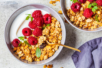 Muesli with raspberries and yoghurt in gray bowl, top view. Healthy food concept.