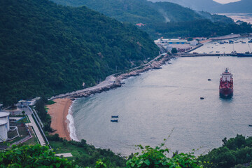 Oil terminal storage tanks sea port cranes. Nature evening horizon water forested mountain, boat, oil refining ship tanker vessel. Business commercial trade fuel energy industry, environment ecology