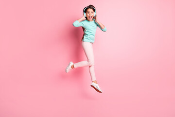 Sticker - Full length body size photo of crazy little hispanic girl jumping up shouting wearing earphones isolated on pink color background