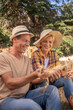 © zinkevych - Smiling male and female farmers shucking corn cobs