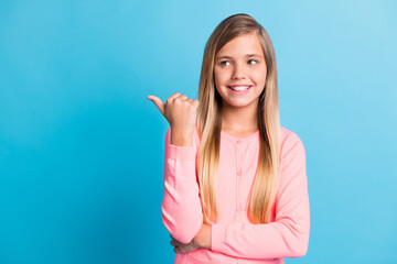 Poster - Photo portrait of girl pointing finger thumb looking at blank space isolated on pastel blue colored background