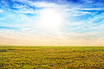 Wall Mural - scenic landscape background of blue sky and faded meadow grass in late autumn. wide view of rural sc