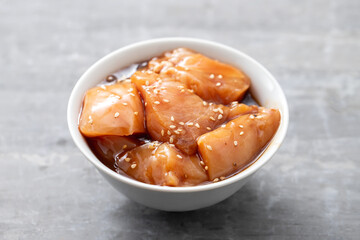 Sticker - raw chicken with sauce and sesame in white bowl