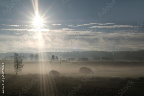 Cuadros en Lienzo Beautiful autumn moody landscape - fields and houses of village shrouded in mist in the morning