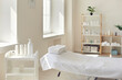 © Studio Romantic - Massage room or beauty parlor with empty bed and ready set of organic skincare products