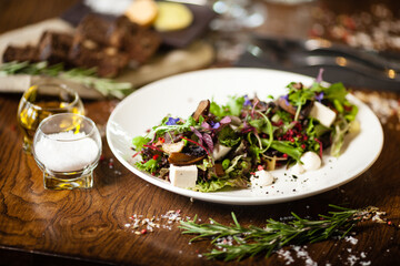 Fresh vegan salad. Avocado, couscous, melon, portobello, soybean, tofu on white plate. Delicious healthy mixed greens food closeup served on a table for lunch in modern cuisine gourmet restaurant.