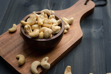 Wall Mural - raw cashew nuts in wooden bowl on rustic table, healthy vegetarian snack