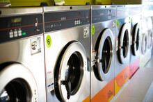 Line Of Industrial Washing Machines In A Public Laundromat.