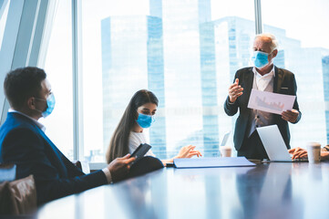 Wall Mural - A group of businessmen meeting a work plan in modern office By wearing a surgical mask to prevent the spread of the virus, new normal lifestyle for business work